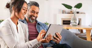 Happy multiethnic mature couple experiences best-in-class tax client experience as they use a digital tablet to review, e-sign, and pay their taxes.